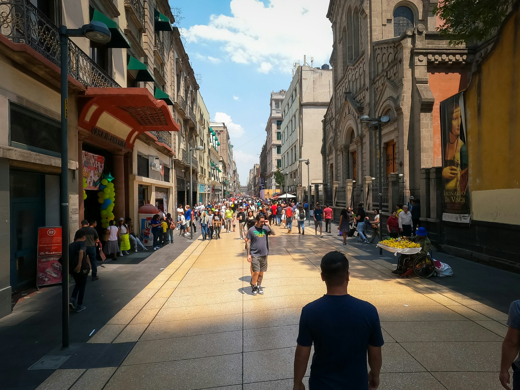 Personas caminando por una calle amplia del centro urbano